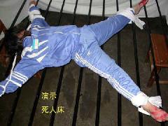 酷刑演示：法輪功學員被綁在死人床上