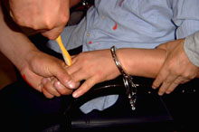 酷刑演示：牙刷鑽指縫，將法輪功學員的五指並攏、捏緊，用牙刷柄在其指縫處用力轉動。