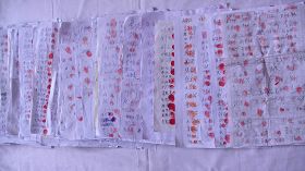 圖：黑龍江省有超過一萬五千民眾為素不相識的法輪功學員挺身而出，在替父鳴冤的秦榮倩的《喊冤昭雪書》上簽名並按上大紅手印。