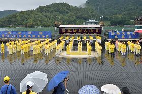 '法輪功學員在細雨中演示功法。'