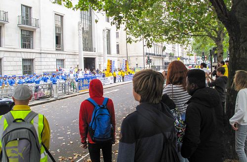 圖3：二零一五年十月十日，法輪功學員在在倫敦中使館對面舉行新聞發布會，一個住宿學校的老師帶著九個學生恰巧路過，師生們第一次聽到法輪功真相
