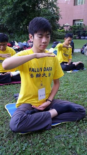 圖2. 余以澄（前一）參加二零一四年七月舉辦的青年學子交流營，圖為當時在中國醫藥大學校園煉功的照片。