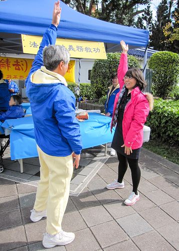 圖9：台北殷小姐（右）現場學功，她感到法輪功很正，表示要好好學煉。