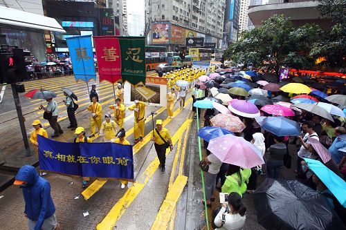 圖6-12：法輪功學員希望民眾了解真相，在遊行隊伍中打出了揭迫害、喚良知、啟善念、勸三退等橫幅。