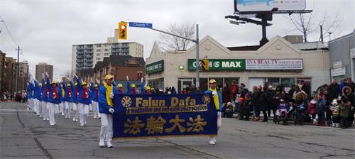 '圖6～7：由法輪功學員組成的煉功隊參加了多倫多市二十五日下午兩點舉行的聖誕遊行。'