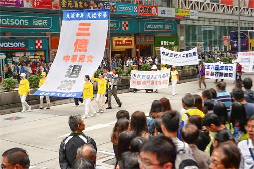 '圖6～12：近千人的遊行隊伍在天國樂團的領頭下從長沙灣遊樂場出發，途經遊客購物熱點，吸引許多人駐足觀看和手機拍攝，大陸遊客親眼看到法輪功，很震撼。'