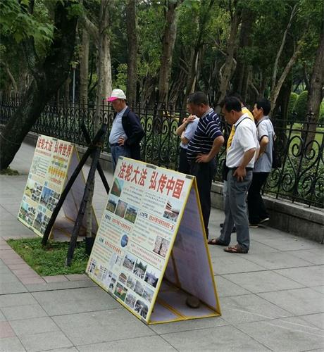 '圖1～2：遊客在台灣台北國父紀念館前的法輪功真相點上認真閱讀展板'
