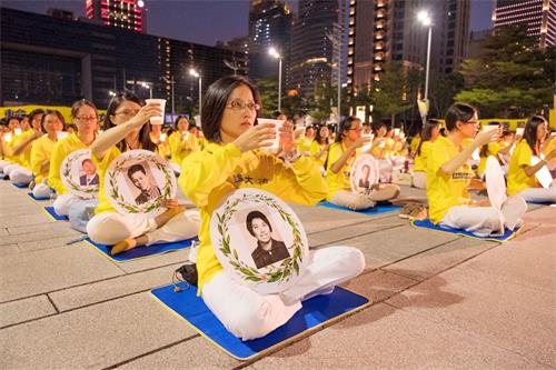 '圖8～9：當夜幕低垂時，用點點的燭光及歌聲悼念在這場迫害中失去生命的法輪功學員。'