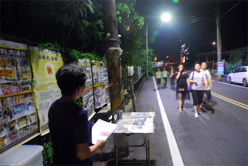 '圖：大陸遊客晚餐後成群從飯店散步至仁義潭畔，路過法輪功學員的真相點。'