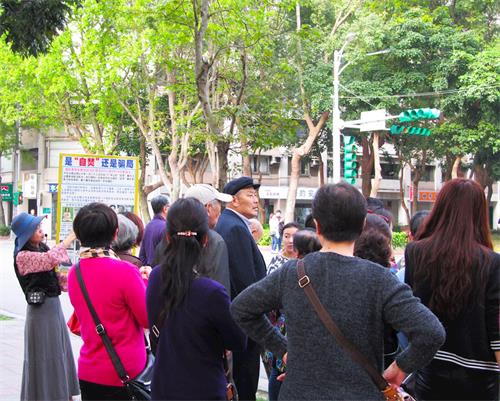 '圖3：中國大陸遊客眼觀展板、耳聽法輪功學員講真相。'