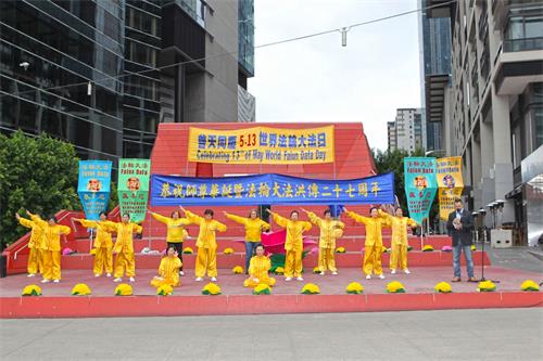 '圖1：二零一九年五月十二日，墨爾本法輪功學員在市中心女王橋廣場（Queensbridge Square）舉行隆重慶典，恭賀第二十屆「世界法輪大法日」和創始人李洪志先生華誕。圖為學員們在展示功法。'