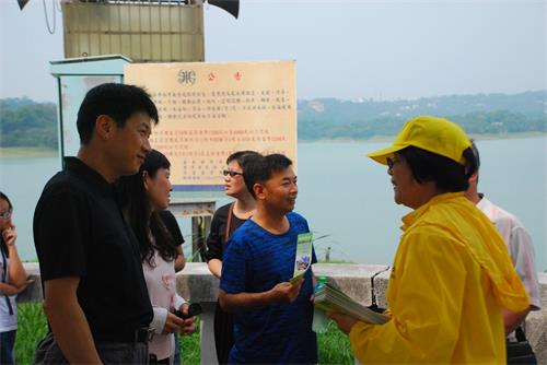 圖3：法輪功學員發放資料向遊客講真相。