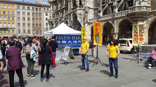 '圖4：二零一九年五月十八日，德國法輪功學員在慕尼黑瑪琳廣場（Marienplatz）舉辦信息日活動，吸引了不少大陸民眾的目光。'