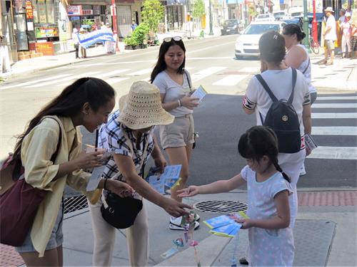 '圖6：一位年輕女士高興地接過象徵平安與幸福的小蓮花。'