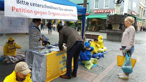 '圖4：二零二零年九月二十六日，法輪功學員在沃爾姆斯（Worms）舉辦信息日活動，向人們介紹法輪大法的美好，中共邪惡迫害法輪功。不少過往行人駐足了解，有的了解真相後，簽名支持制止迫害。'