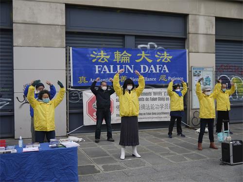 '圖1：十二月二十六日星期六，法輪功學員在巴黎藝術與職業廣場演示法輪功功法、傳播真相。'