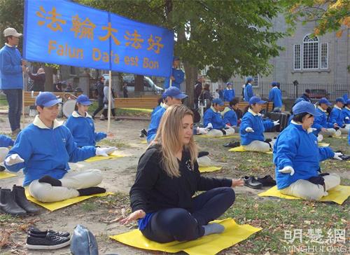 '圖10：蒙特利爾學生艾裏芙（Elif，中）初次次嘗試法輪功功法，感覺到很強的能量。'