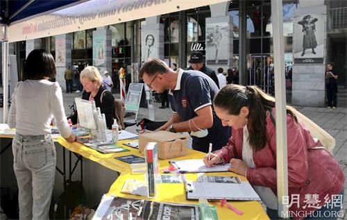 '圖4：十月二日，在康士坦茨（Konstanz）的奧古斯緹納（Augustinerplatz）廣場上，了解真相後的路人簽名支持制止中共活摘罪行。'