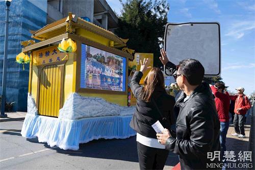 '圖10：巴拿馬遊客Tony Bonya和太太Nadi很喜歡法輪功學員的花車'