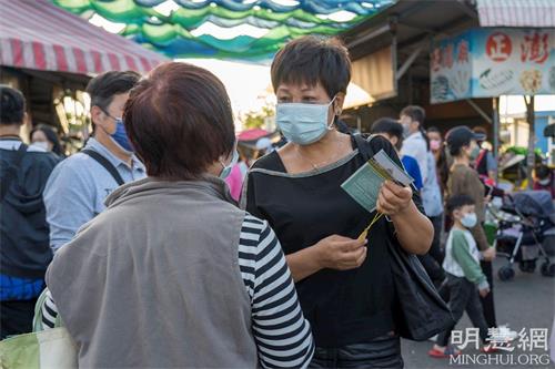 '圖4：一位女士想學煉，向法輪功學員詢問修煉方法和煉功點資訊。'