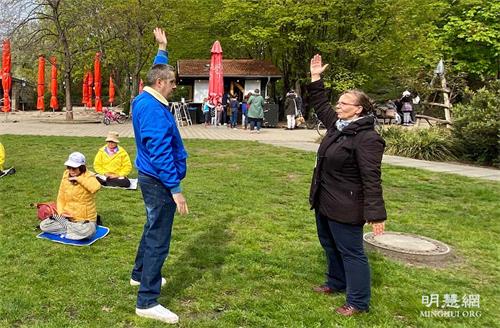 '圖8：碧爾吉特（右）跟著學煉功法，半小時後她學完了全部五套功法，高興的說她會再來找學員一起煉功。'