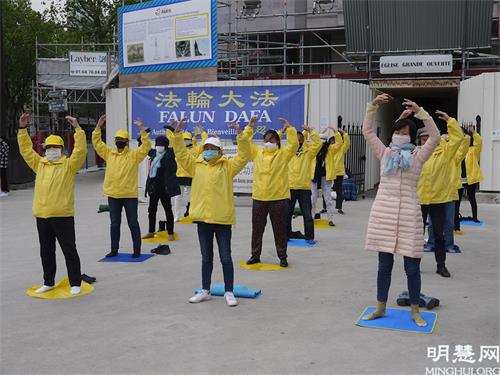 '圖1：五月二十三日，法輪功學員在紅山聖皮埃爾（ Saint-Pierre de Montrouge）教堂前向行人展示法輪功功法，介紹法輪功。'