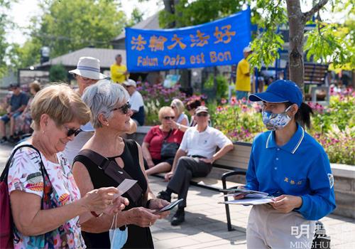 '圖6：路人與學員交談，了解法輪功的真相。'