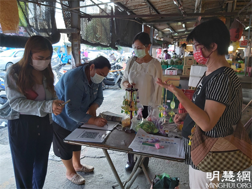 圖1：法輪功學員在雲林虎尾黃昏市場講真相發送蓮花書籤及真相資料。