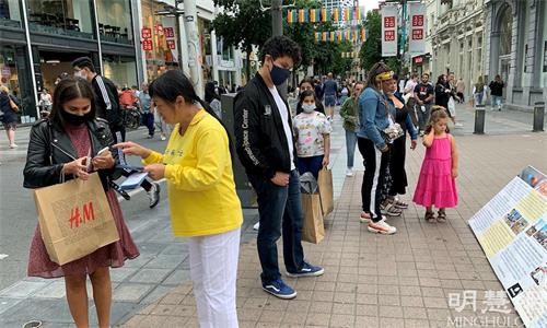 '圖1～2：比利時安特衛普著名的梅爾購物街（Antwerp Meir Street）上，路人駐足了解法輪功真相。'