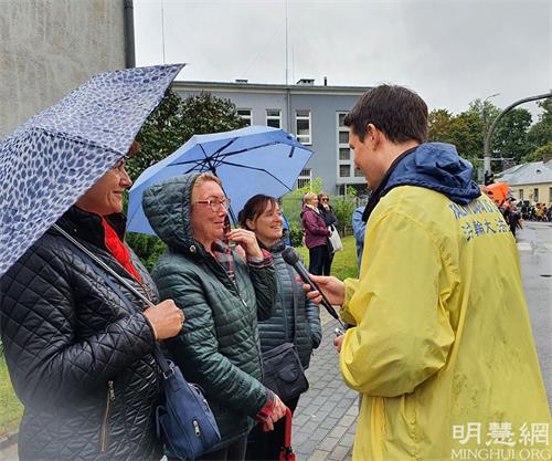 '圖11：觀眾約蘭特（Jolant，左二）女士注意到舞龍者身上的T恤衫都寫著真、善、忍字樣，她說：「我覺得太好了，這是我們在現實生活中丟失很久的美好信仰，需要恢復出來，世界需要真、善、忍」。'