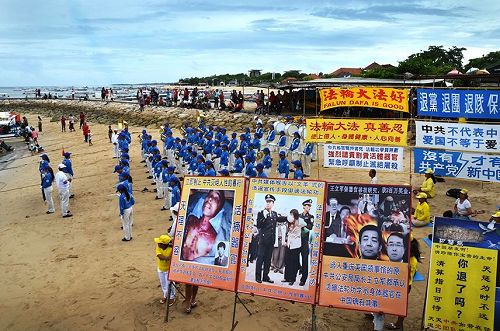 圖2、丹中伯努阿碼頭前的法輪功真相橫幅和天國樂團表演