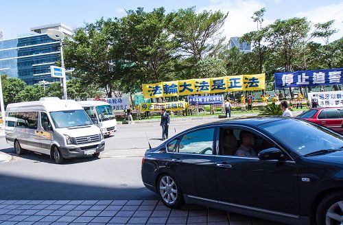 二十五日強衛一行車隊到達最後一站高雄軍鴻酒店，法輪功學員聚集一波波的譴責聲浪，強衛一行快步閃入酒店，狼狽不堪。