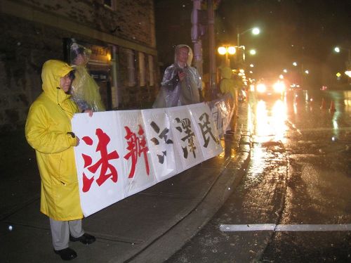 '圖5：加拿大博物館前大雨中在夜晚裏等待李克強一行國宴結束的法輪功學員'