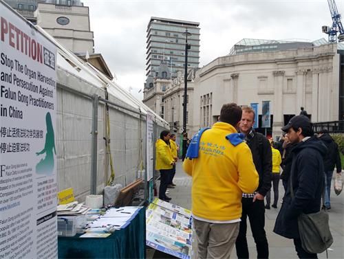 圖6：二零一八年十月二十七日，法輪功學員本（Ben）在特拉法加（Trafalgar Square）廣場向在倫敦工作的奧利佛（Oliva）和弗拉維奧（Flavio）深入講真相