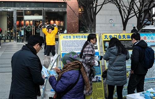 '圖5～6：民眾看展板，了解法輪功真相'