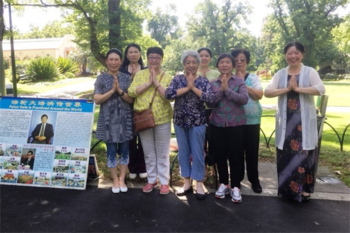 '圖2：二零一八年十二月二十七日，墨爾本著名旅遊景點費茨羅伊公園（Fitzroy　Gardens）真相點的法輪功學員恭祝師尊新年好。'