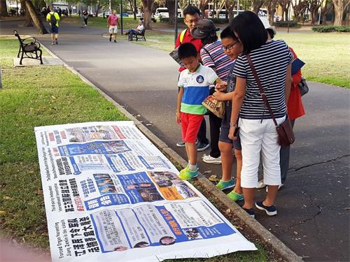 '圖6：從中國來旅遊的一家人一起看真相展板並一起退出中共組織'