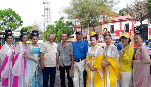 '圖6：邦咯島當地居民王文彬（左五，灰色衣服），從法輪功遊行一開始直到結束都在隊伍中發資料。'