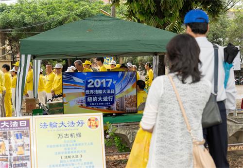 圖5～6：2019年5月5日，在高雄橋頭糖廠提前慶祝「世界法輪大法日」，民眾駐足觀看法輪大法洪傳世界圖片展和電視影片。