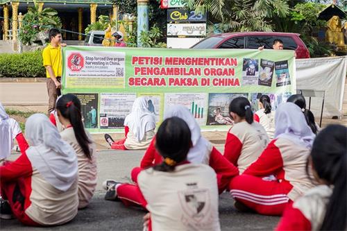 '圖12：二零一六年十一月十一日，巴丹島法輪功學員第二次到Kolese Tiara Bangsa 高職教學生煉法輪功功法。教功後，法輪功學員向Tiara Bangsa 高職學生講述中共活摘法輪功學員器官的罪行。'