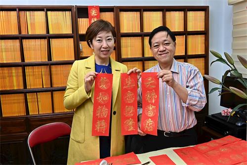 '圖2：前區議員林詠然（右）寫揮春，恭祝天梯書店生意貨如輪轉。'