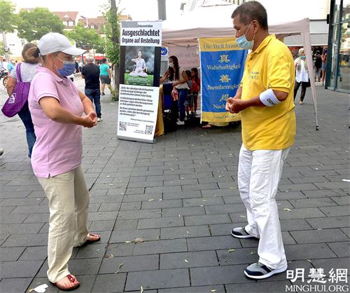 '圖5：學員教中年女士法輪功功法。'