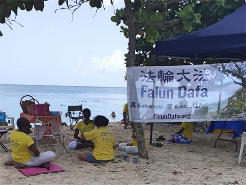 圖1：二零二二年七月二十四日，法輪功學員在路易港的蘇弗萊爾海灘傳播法輪功真相。圖中法輪功學員正在煉功。